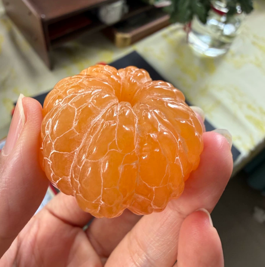 A carved yellowstone orange, symbolizing a tranquil mind, solidified learning, and the safeguarding of wisdom.