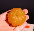 A carved yellowstone orange, symbolizing a tranquil mind, solidified learning, and the safeguarding of wisdom.