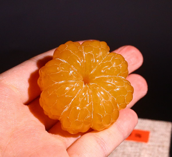 A carved yellowstone orange, symbolizing a tranquil mind, solidified learning, and the safeguarding of wisdom.