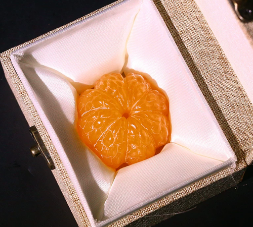 A carved yellowstone orange, symbolizing a tranquil mind, solidified learning, and the safeguarding of wisdom.